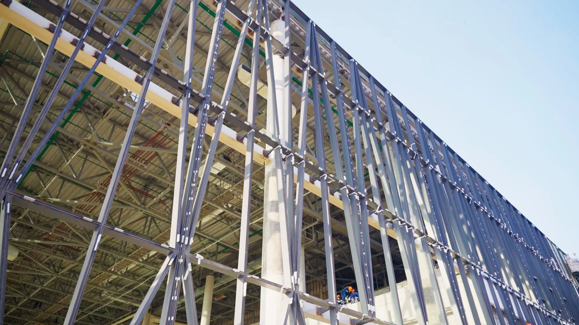Steel frame of the terminal facade seen from below, with the roof structure behind it.
